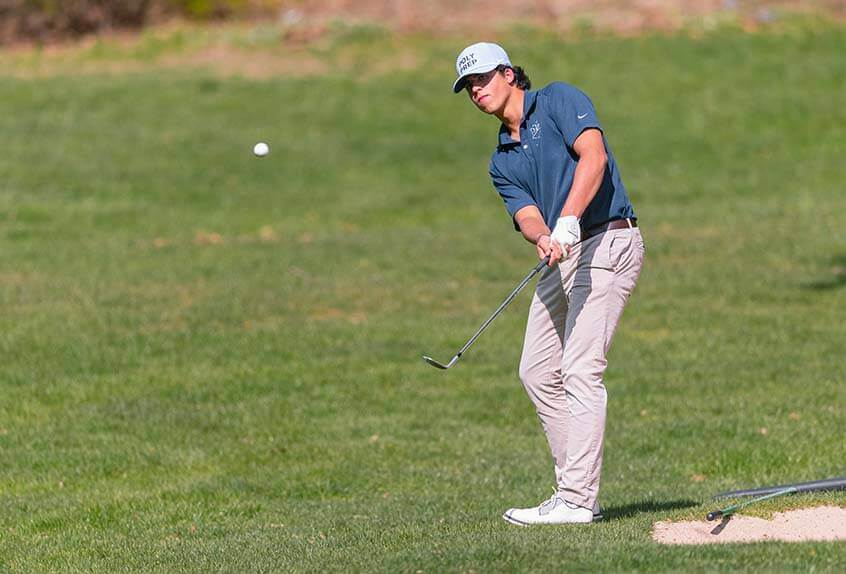 Poly golf team member hitting a ball