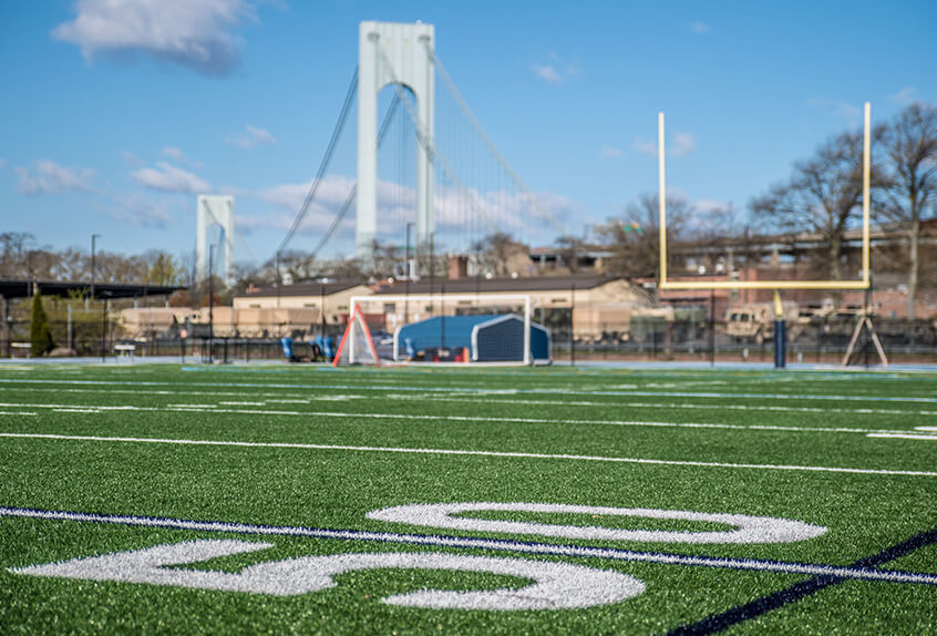 Football 50 yard line with bridge in backgroun