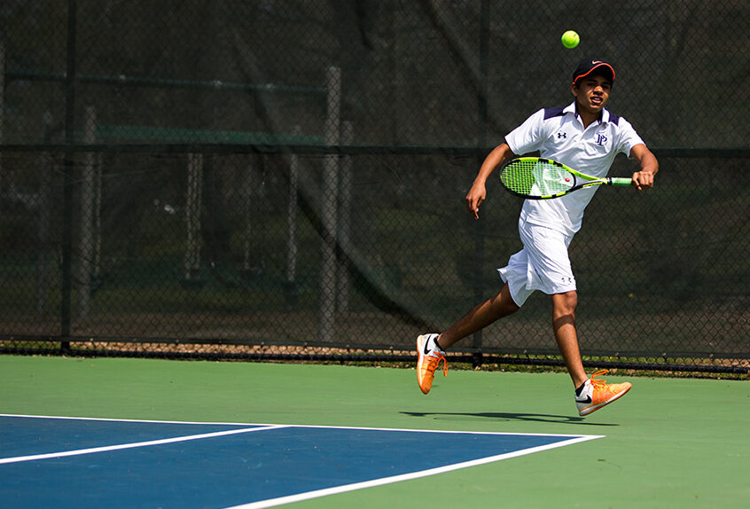 Boys Tennis player hitting the tennis ball