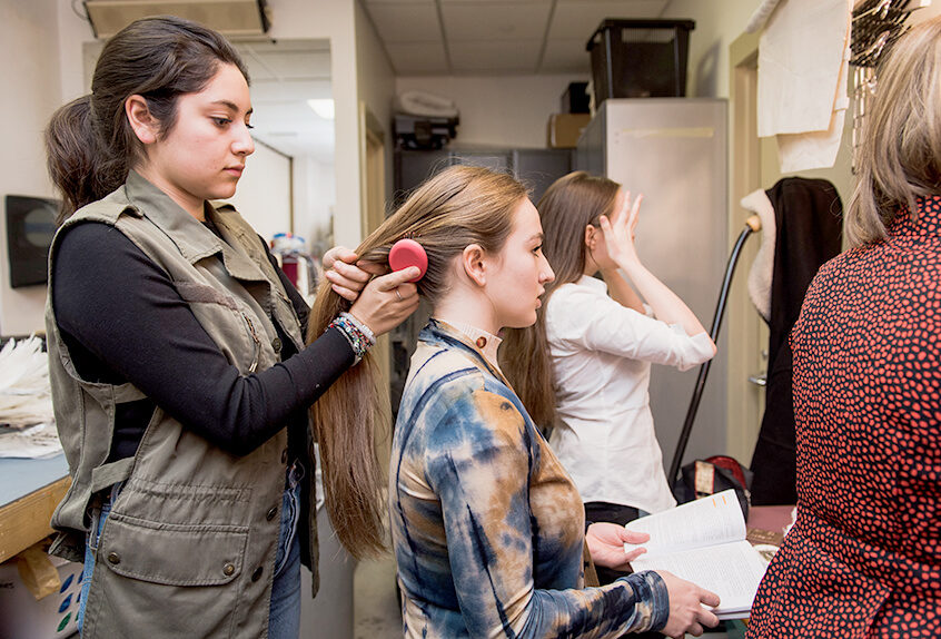 Alexandra Nava-Baltimore works backstage doing hair and makeup for performance.