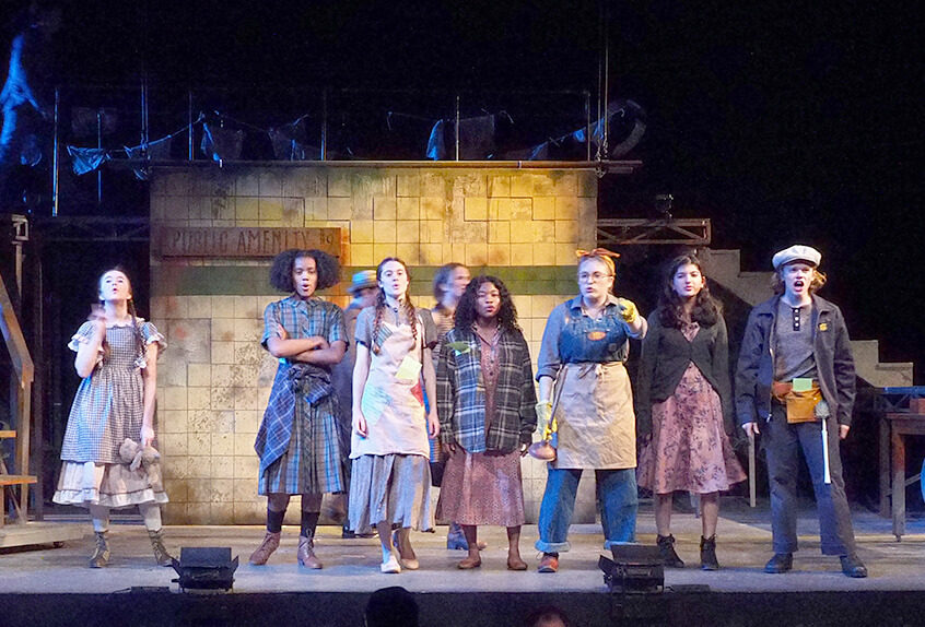 Cast on stage during Upper School musical Urinetown