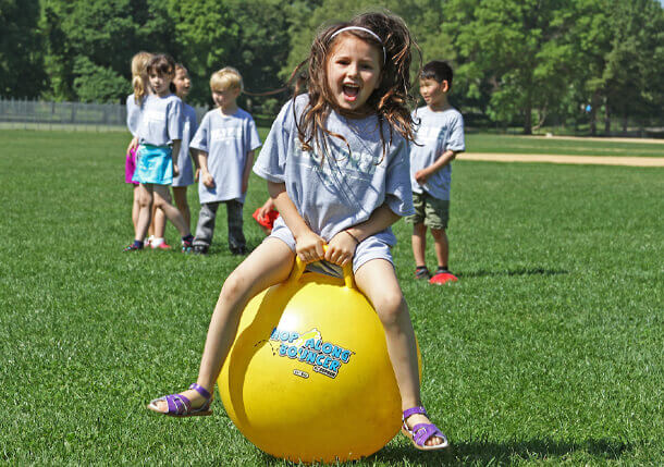 Poly Prep student playing on a bouncy ball