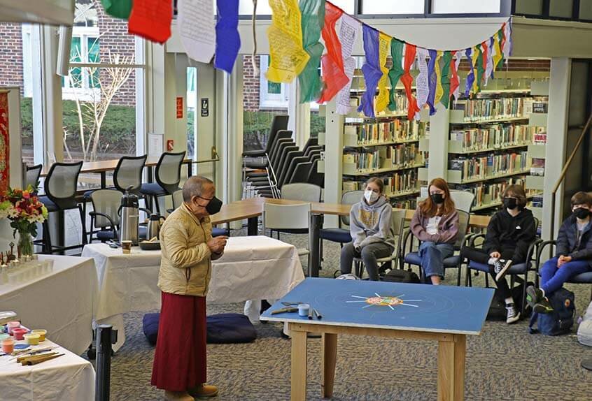 Lama Tenzin visits with students in library