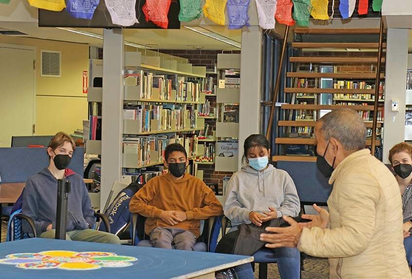 Lama Tenzin visits with students in library