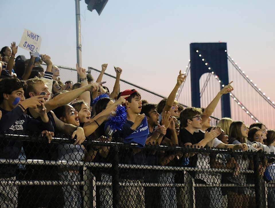 Crowds cheering on Blue Devil Night with bridge in background