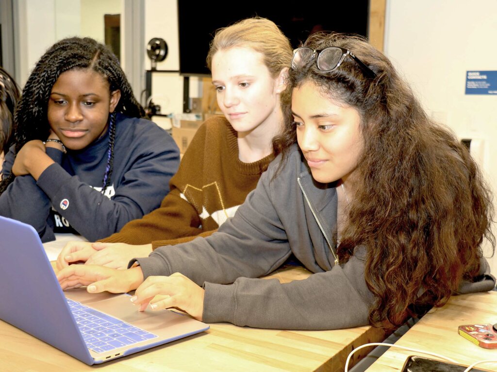Poly students coding on a laptop