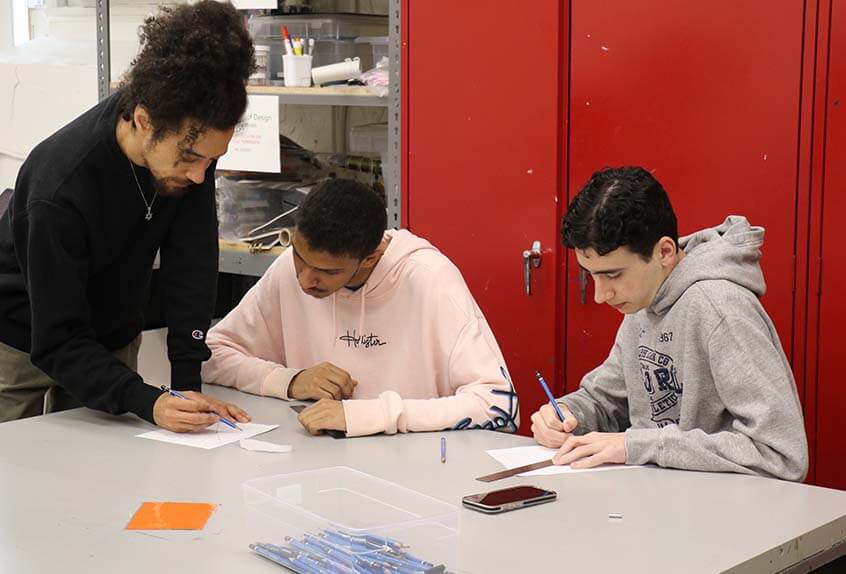 Teacher Dan Herwitt works with students in his Graphic Novels class