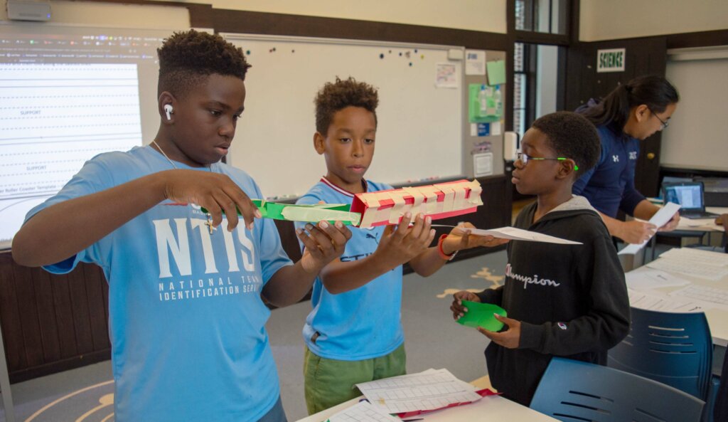 Asher Blumberg, Grayson Daley, Malakhi Seales collaborating in the classroom