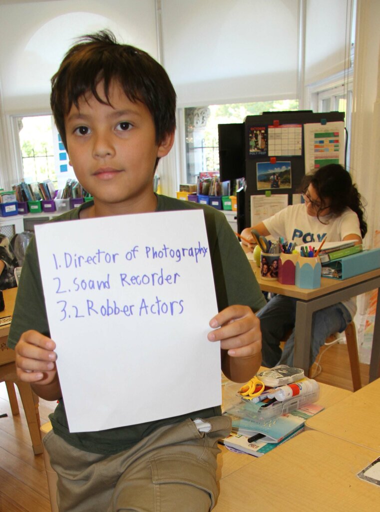 Lower School After School student with sign for filmmaking