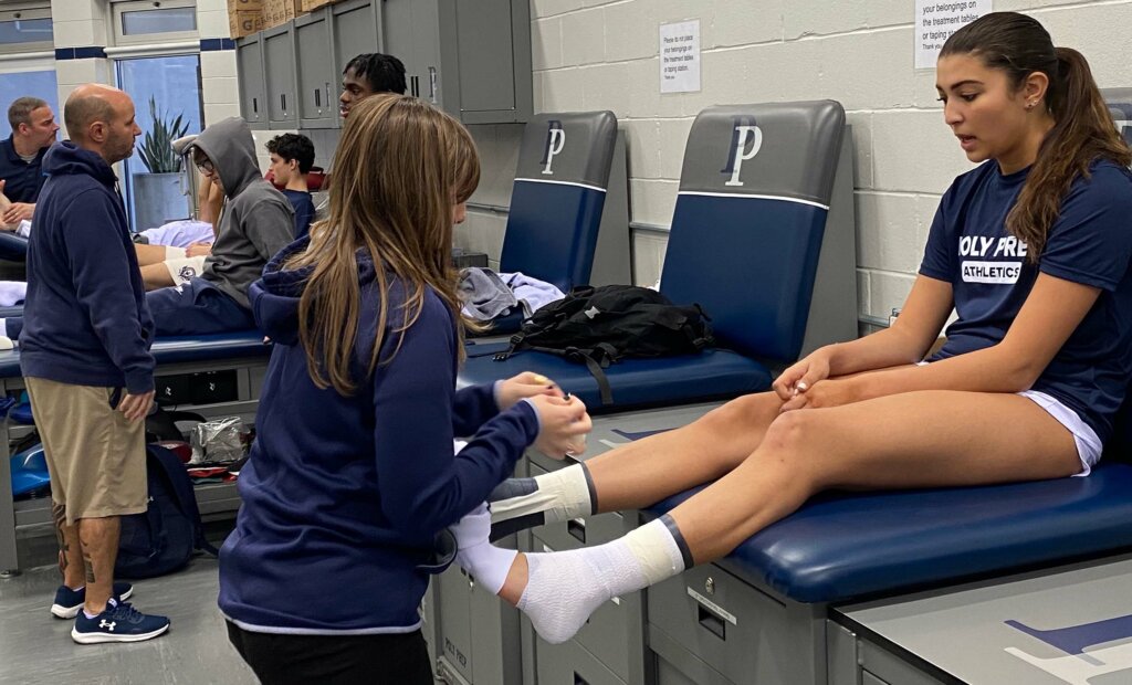 Athletic Trainer Alyssa Alaimo works on student's ankle
