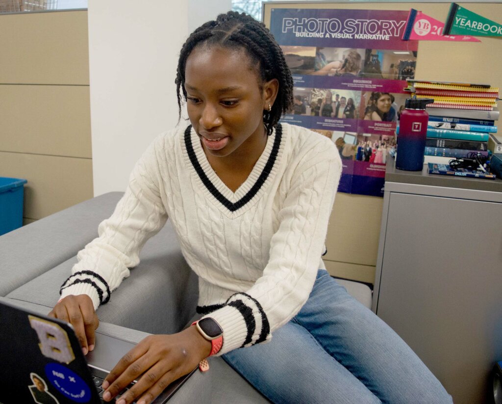 Brianna Sylvain working on computer in Communications Office.