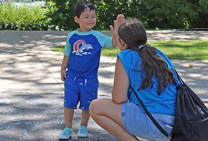 Kid giving counselor high five at Poly Summer day camp