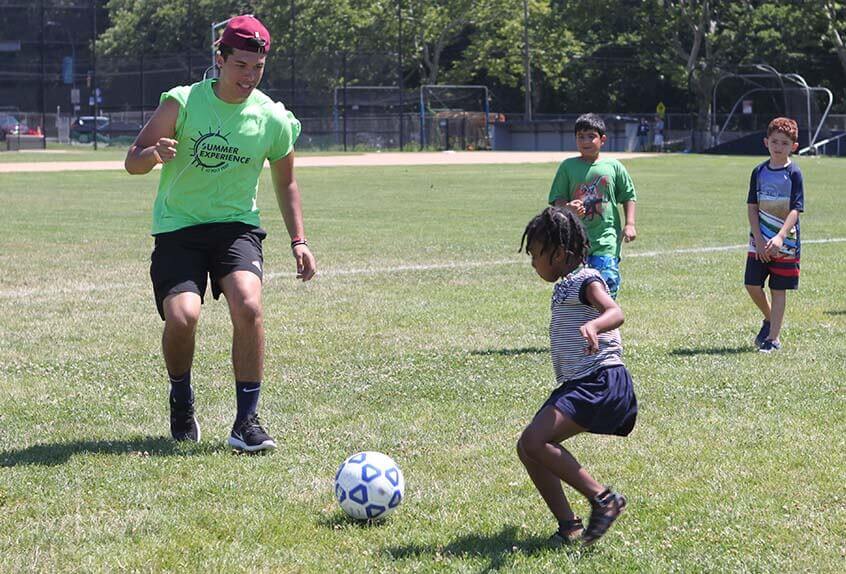 Girls and boys playing soccer at Poly Summer day camp