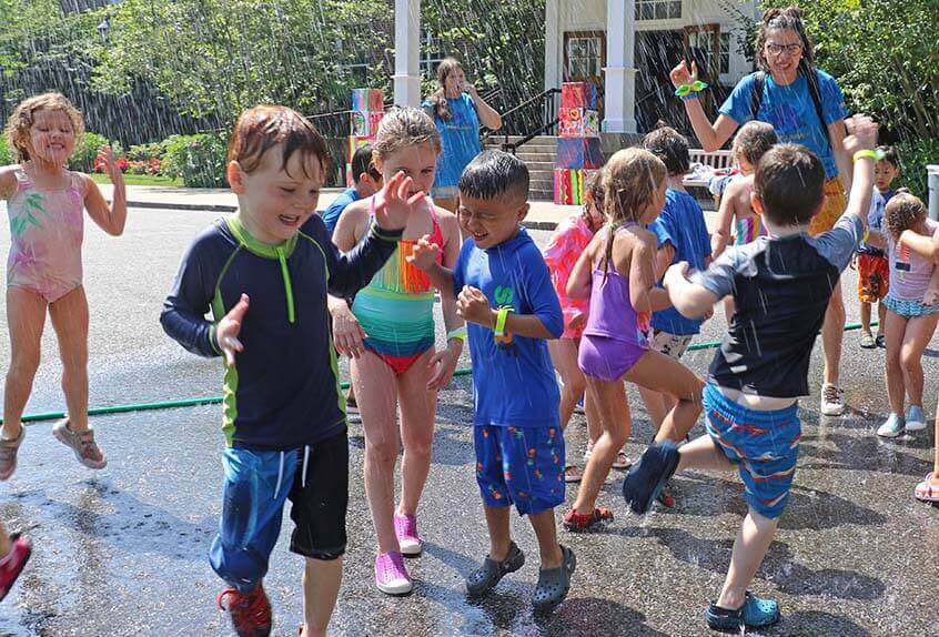 Kids enjoying sprinkler at Poly Summer day camp