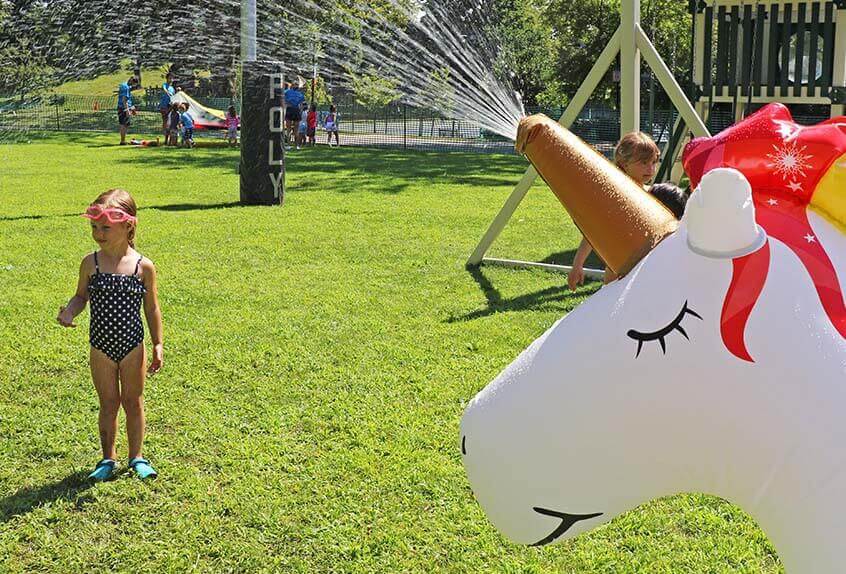 Girl enjoying unicorn sprinkler at Poly Summer day camp
