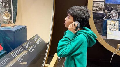 Poly Prep Lower School Grade 3 student listens to audio Louis Armstrong House Museum