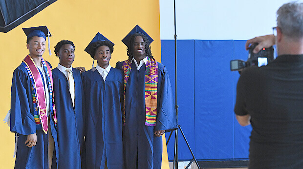 Poly Prep Portrait of a Graduate - four grads being photographed with yellow backdrop